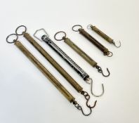A collection of six hanger weight scales comprising five brass hangers and one Pioneer hanger,