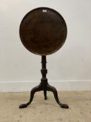 A George III mahogany tilt top table, the dished circular top raised on a ring turned column and