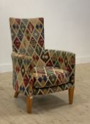A vintage armchair, upholstered in golfing related fabric, raised on square tapered front