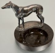 A loose change dish with silver plated cast metal Greyhound standing figure mounted on brown