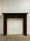 A stained hardwood fire surround with reeded pilasters. Aperture H100cm, W100cm.