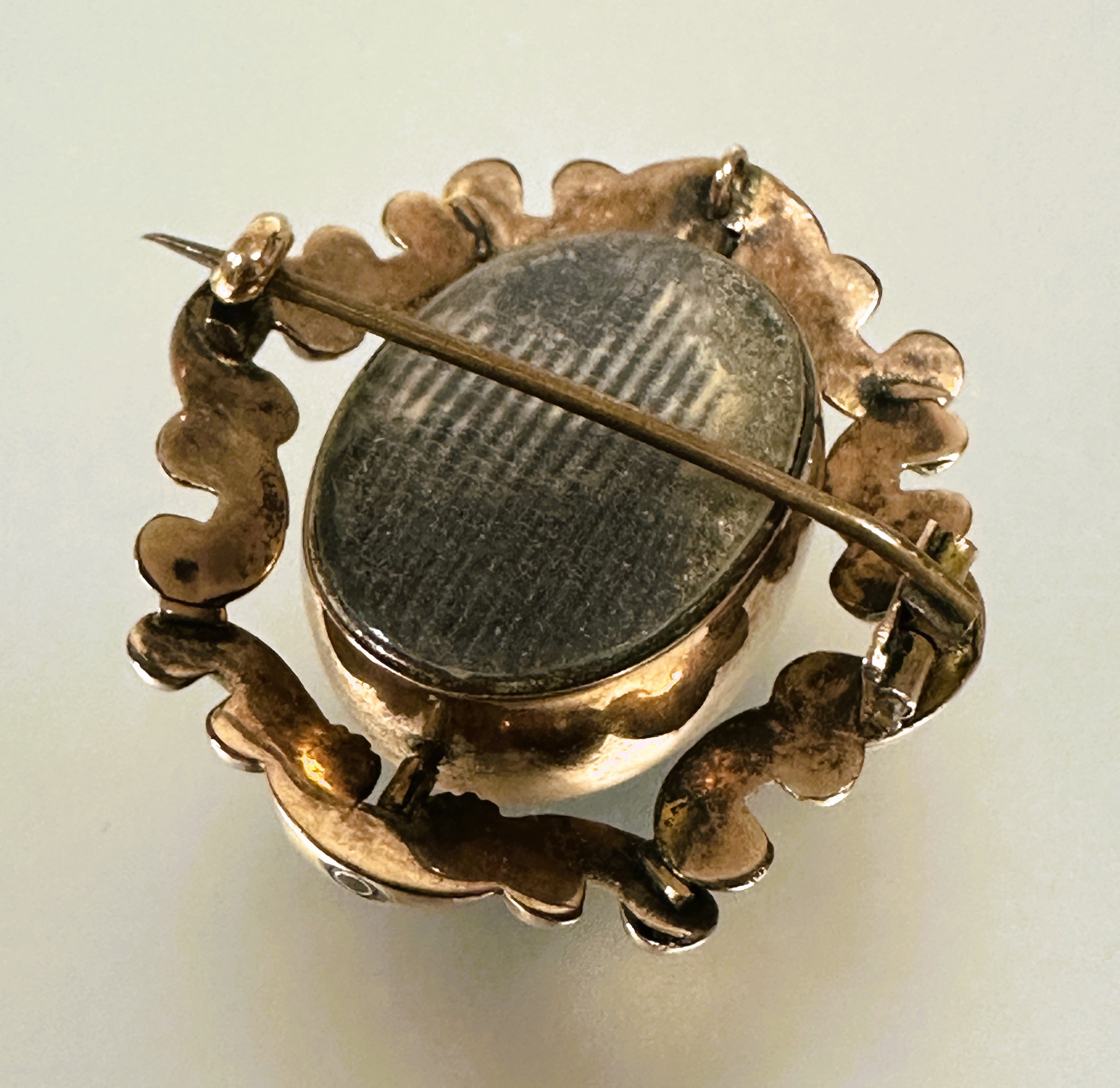 A Victorian yellow metal brooch with central revolving glazed oval panels enclosed within a rococo - Image 4 of 4