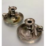 A pair of late Victorian Epns chamber candlestick holders with leaf scroll handles complete with