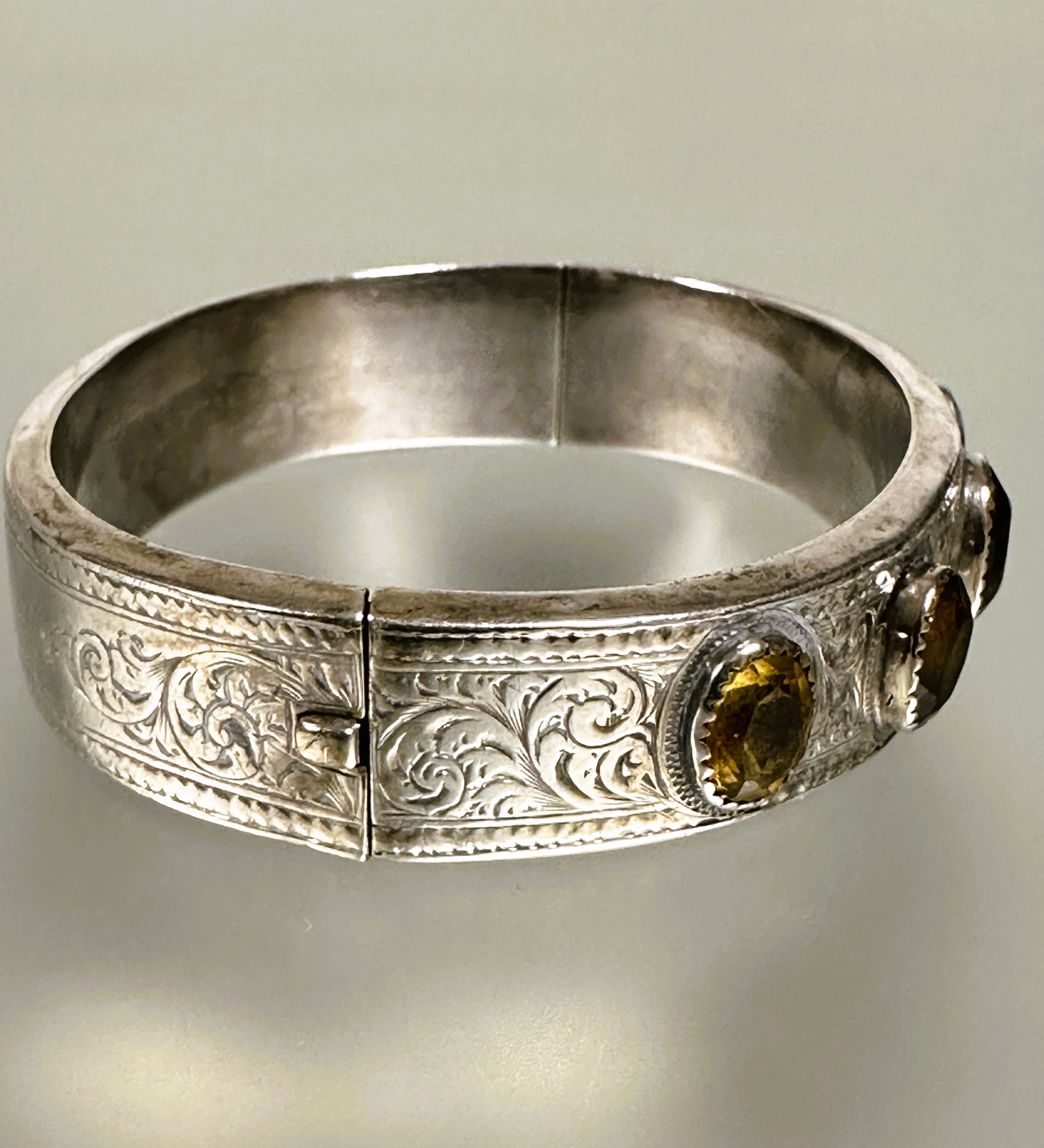 A late Victorian white metal engraved stiff hinged hollow bangle with five oval colette set - Image 2 of 5