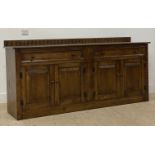 A reproduction oak ledge back sideboard, fitted two frieze drawers and two pairs of panel doors