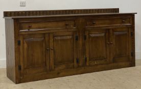 A reproduction oak ledge back sideboard, fitted two frieze drawers and two pairs of panel doors