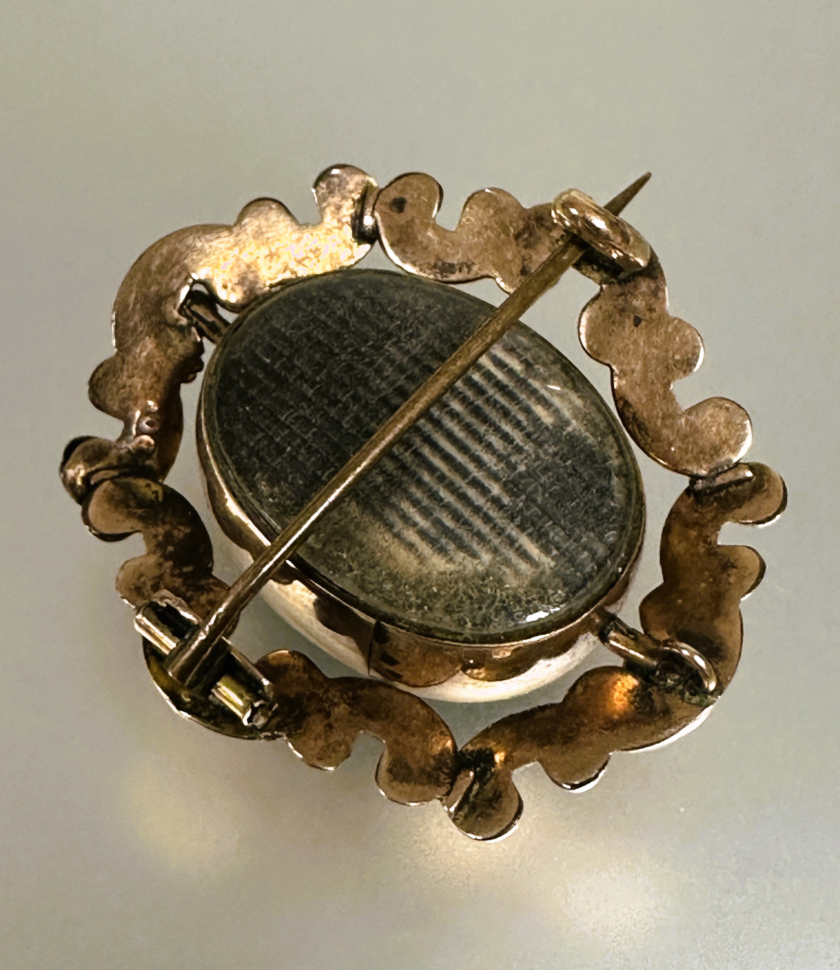 A Victorian yellow metal brooch with central revolving glazed oval panels enclosed within a rococo - Image 3 of 4