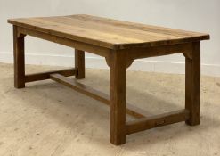 A large traditional reclaimed pine refectory type dining table, the rectangular top raised on square