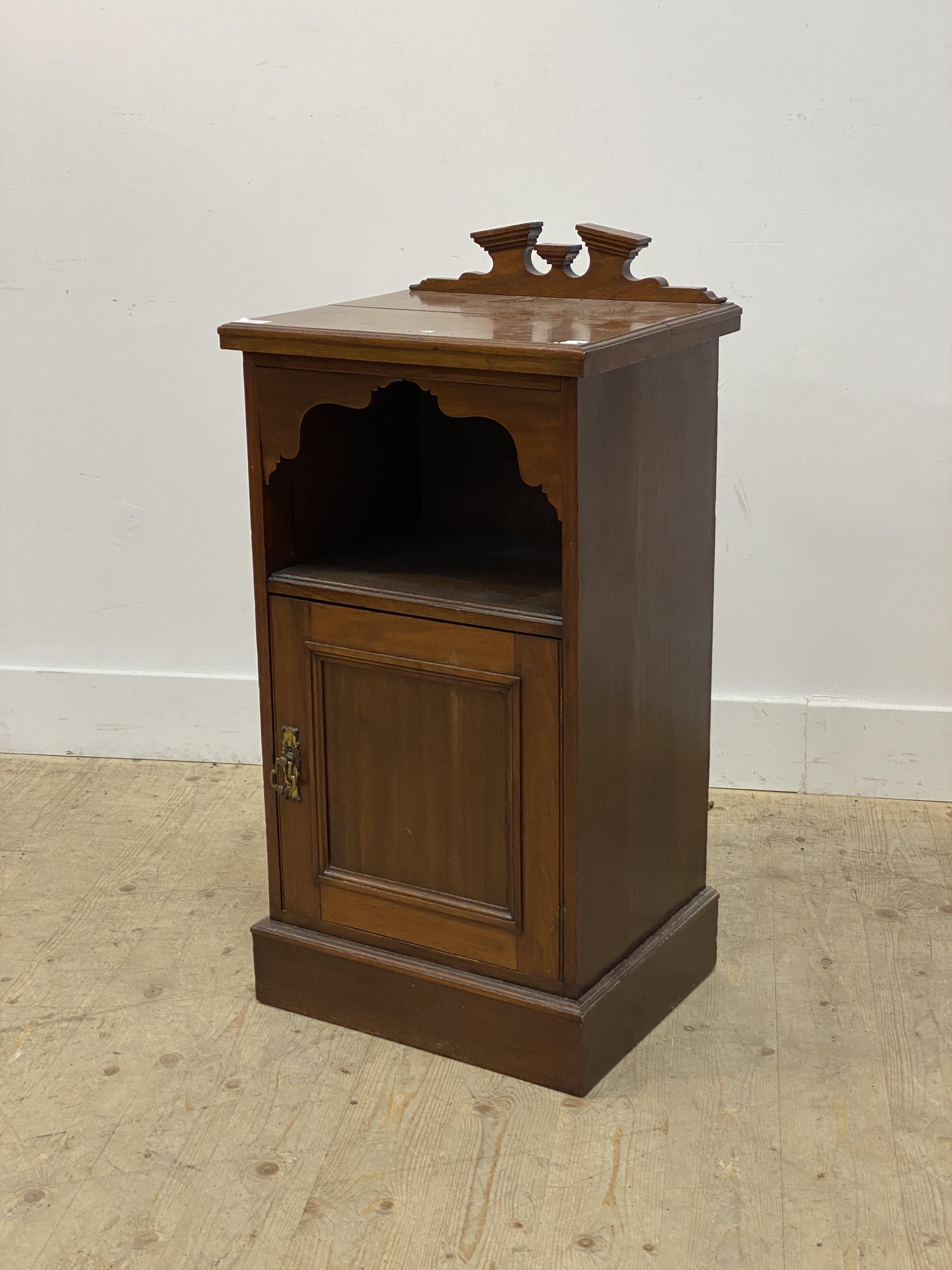 An early 20th century walnut bedside cabinet, with raised back over open shelf and panelled cupboard