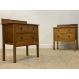 A pair of 1940's oak veneered chests, each with carved ledge back over two drawers, raised on