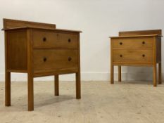 A pair of 1940's oak veneered chests, each with carved ledge back over two drawers, raised on