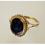 A 9ct gold oval faceted amethyst collette set dress ring with rope pattern border approximately