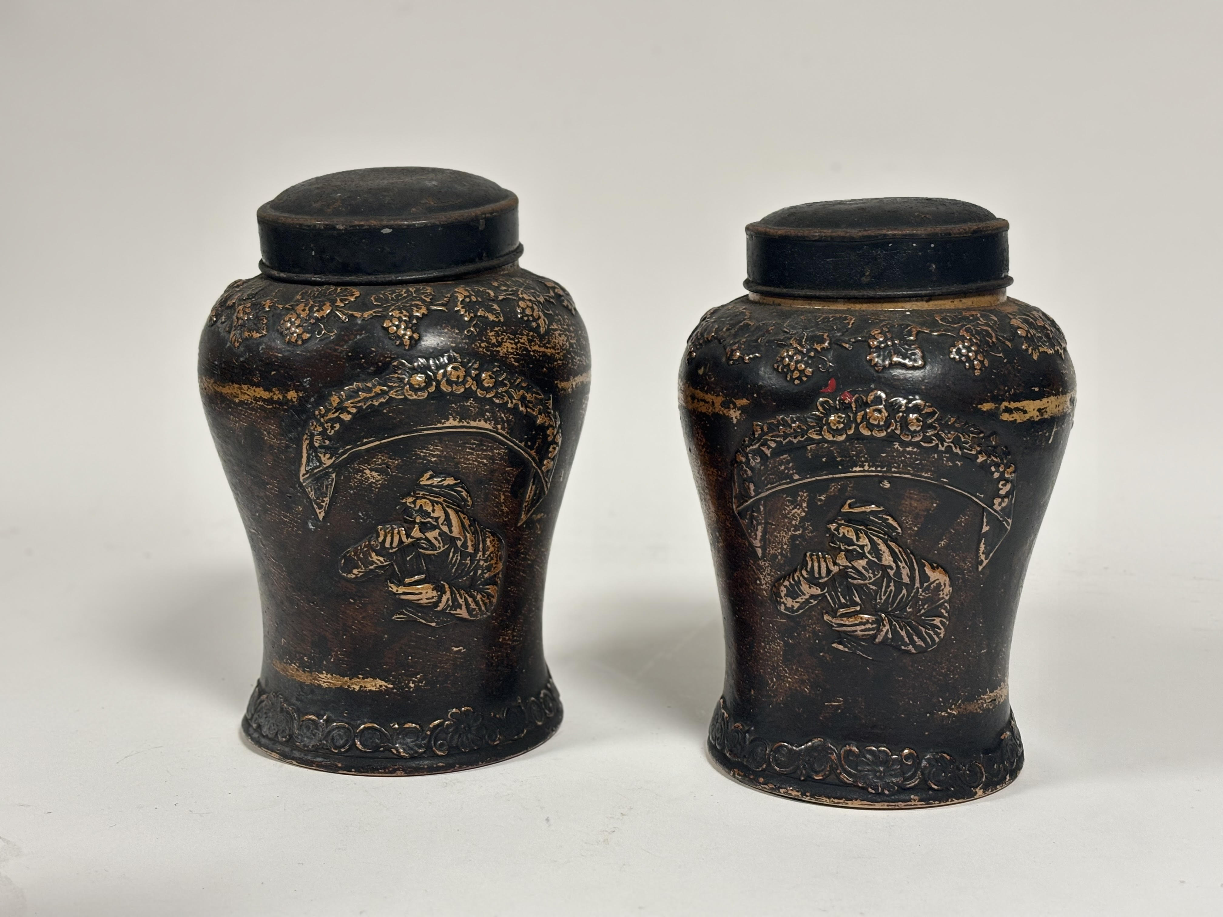 A near pair of Stoneware tobacco jars and towal/metal covers with Art Nouveau style grape vine
