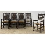 A set of eight stained ash ladderback carver dining chairs, each with a rush seat and raised on