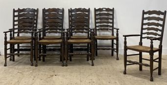 A set of eight stained ash ladderback carver dining chairs, each with a rush seat and raised on