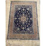 A Persian style rug, the dark blue field with centre medallion and lotus head motifs and bordered