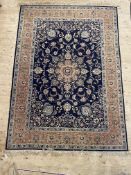 A Persian style rug, the dark blue field with centre medallion and lotus head motifs and bordered
