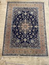 A Persian style rug, the dark blue field with centre medallion and lotus head motifs and bordered