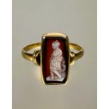 A 19thc style yellow metal ring set rectangular shell carved cameo depicting a figure in standing in