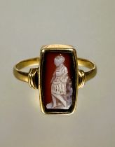 A 19thc style yellow metal ring set rectangular shell carved cameo depicting a figure in standing in