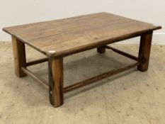 A rustic hardwood coffee table, the rectangular top raised on square section supports united by