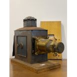 A Victorian brass and tin magic lantern by J. Lizars of Aberdeen, on an oak base L60cm.