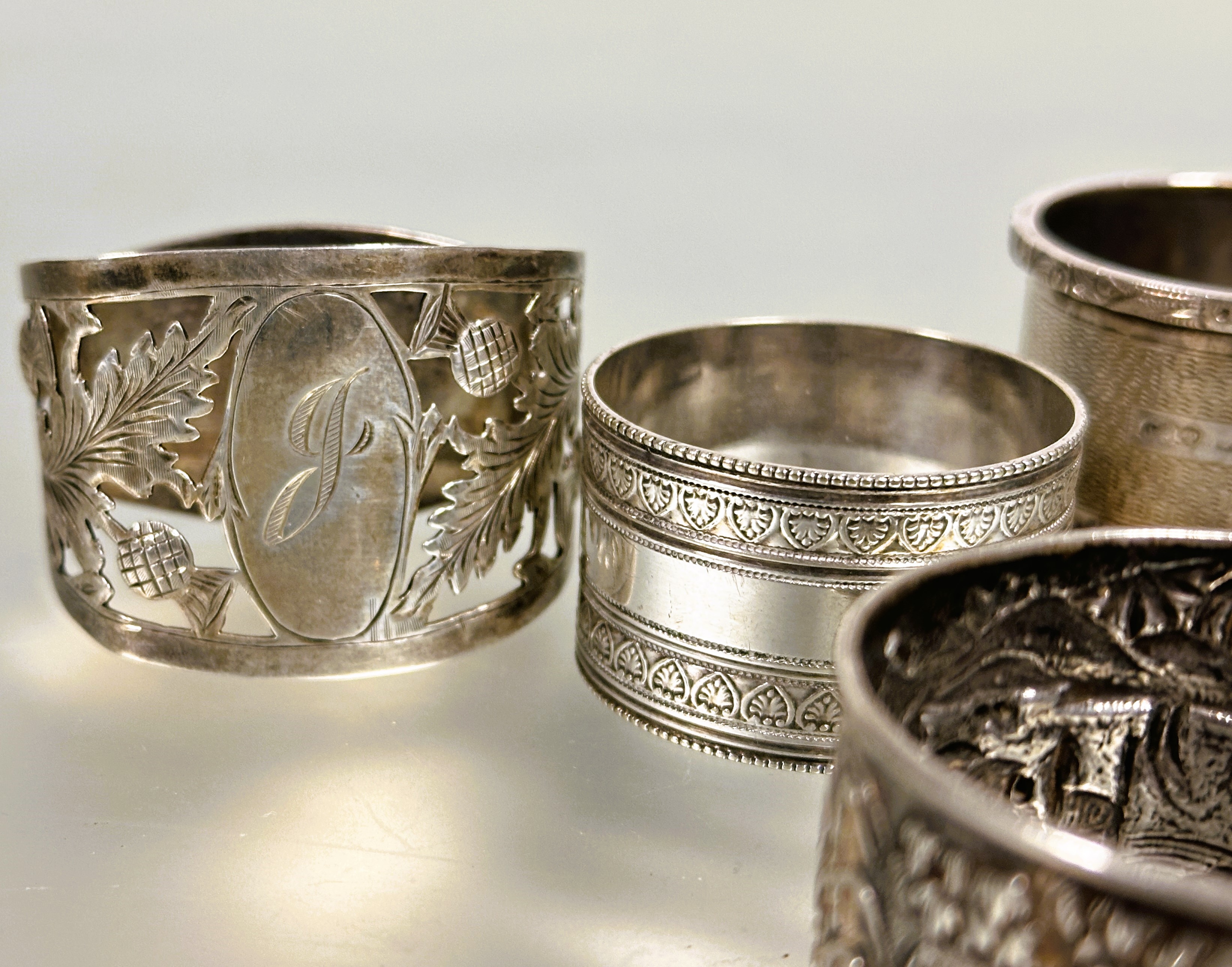 A collection of napkin rings to include a Birmingham silver with engine turned decoration and cast - Image 2 of 3