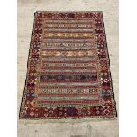 A hand knotted Soumak rug, brightly coloured and of lineal design. 126cm x 190cm.