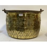 A 19th century hammered brass log bucket, with wrought iron swing handle, and floral motifs. D43cm.