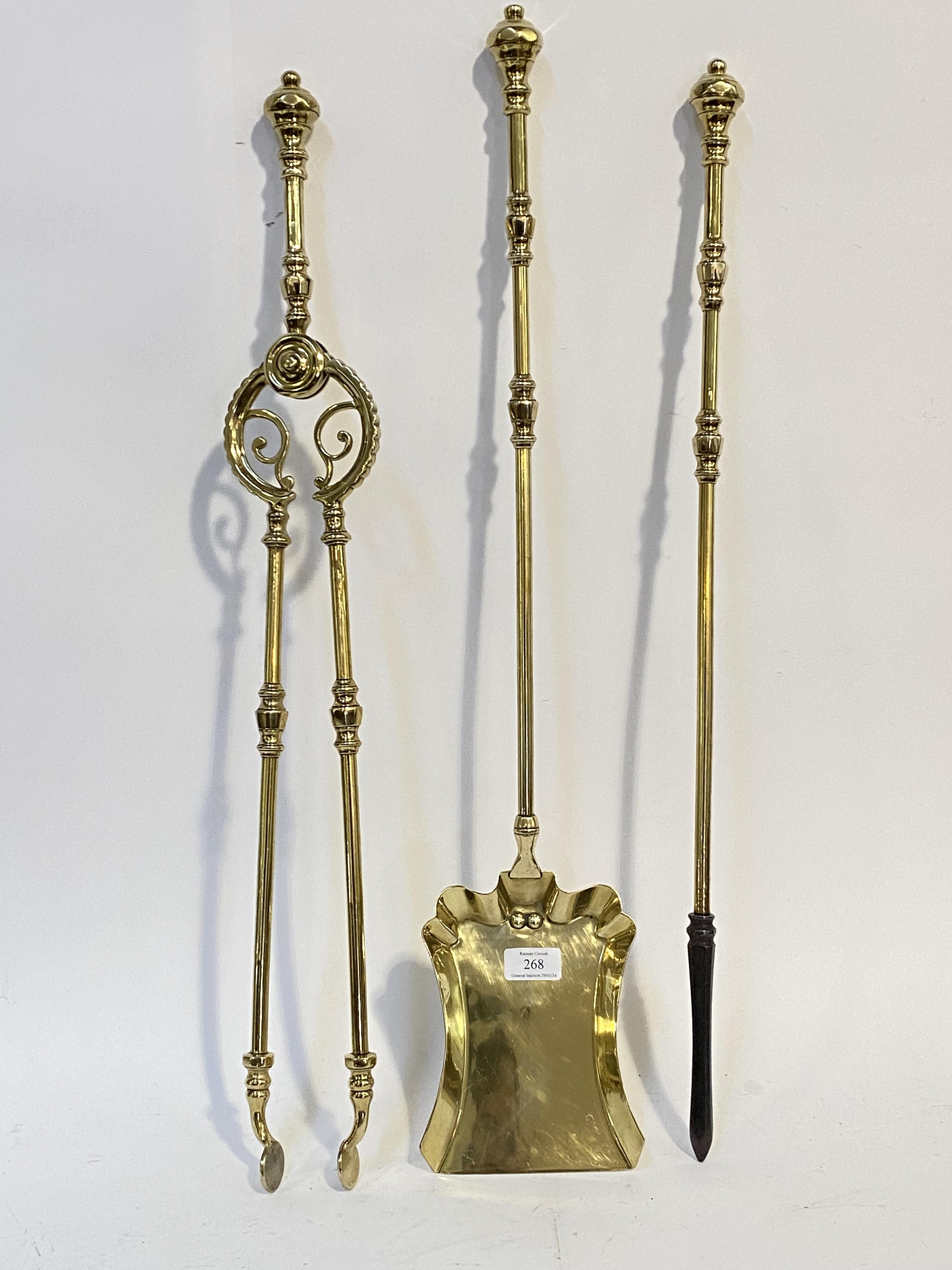 A late Victorian three piece cast brass fireside companion set, comprising a poker, pair of tongs,