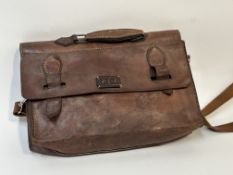A leather light brown satchel with J.L.S initialled patch sewn to the front, with silver hardware