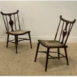 A pair of Edwardian Arts and Crafts chairs, with shaped crest above spindle and splat back,