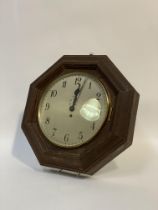 An early 20th century single train wall clock in an octagonal oak case, the silvered dial with