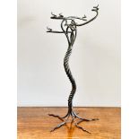 A modern wrought iron scrolling six branch candle stand of tree like design raised on five scrolling