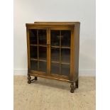 An early 20th century stained oak bookcase, with two glazed doors opening to shelves behind,