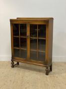 An early 20th century stained oak bookcase, with two glazed doors opening to shelves behind,