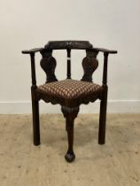 A 19th century oak corner chair, the crest rail, out-swept arms and splats carved with acanthus