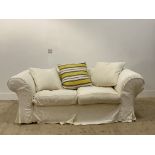 A chesterfield sofa, with a loose fitted white cotton cover having embroidered floral design,