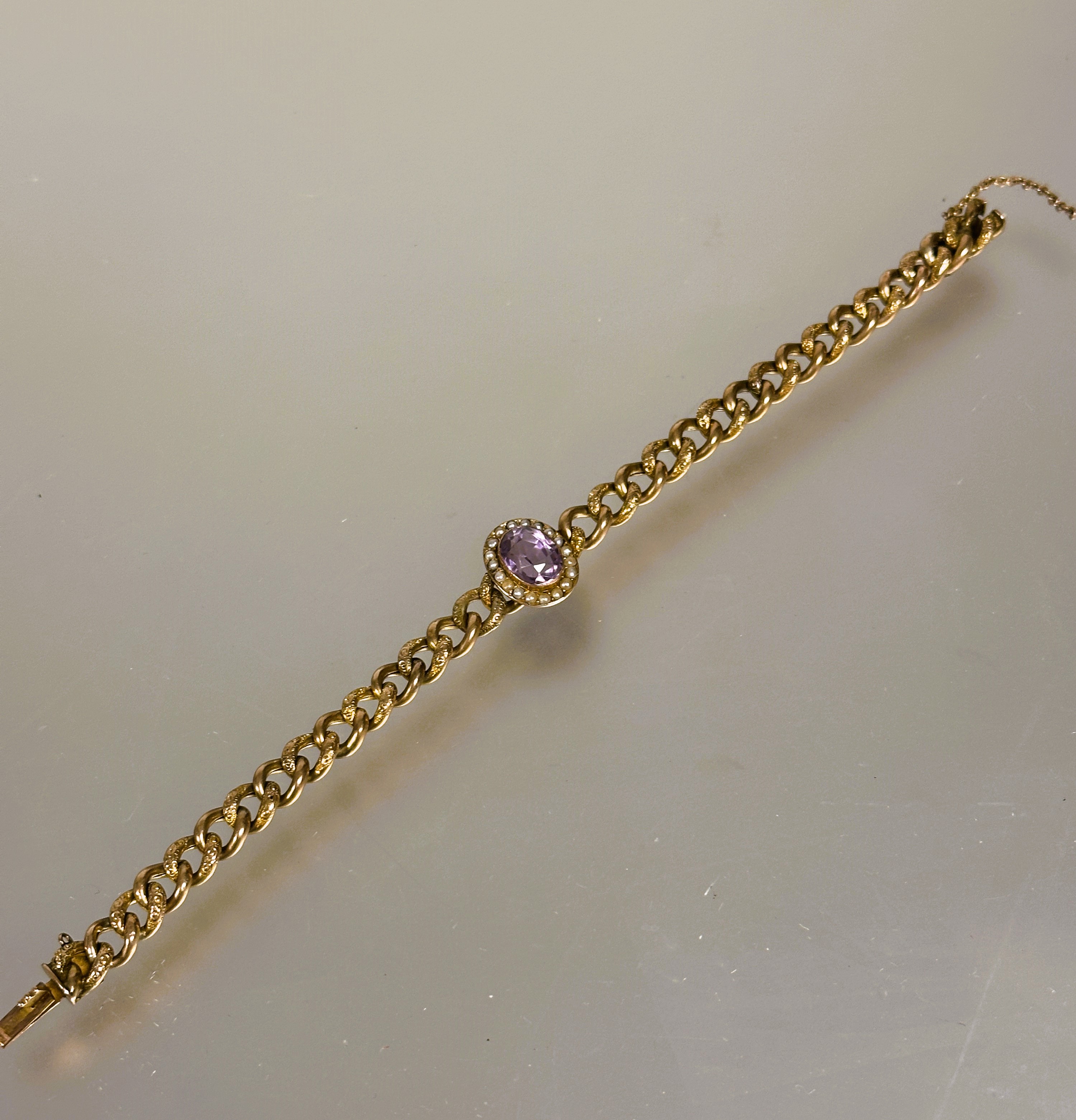 A late 19thc 9ct gold engraved kerb link chain bracelet with clasp fastening and safety chain