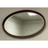 A mid-century teak oval framed wall mirror. 44cm x 72cm.