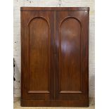 A Victorian mahogany double wardrobe, with two arch panel doors enclosing an interior fitted with