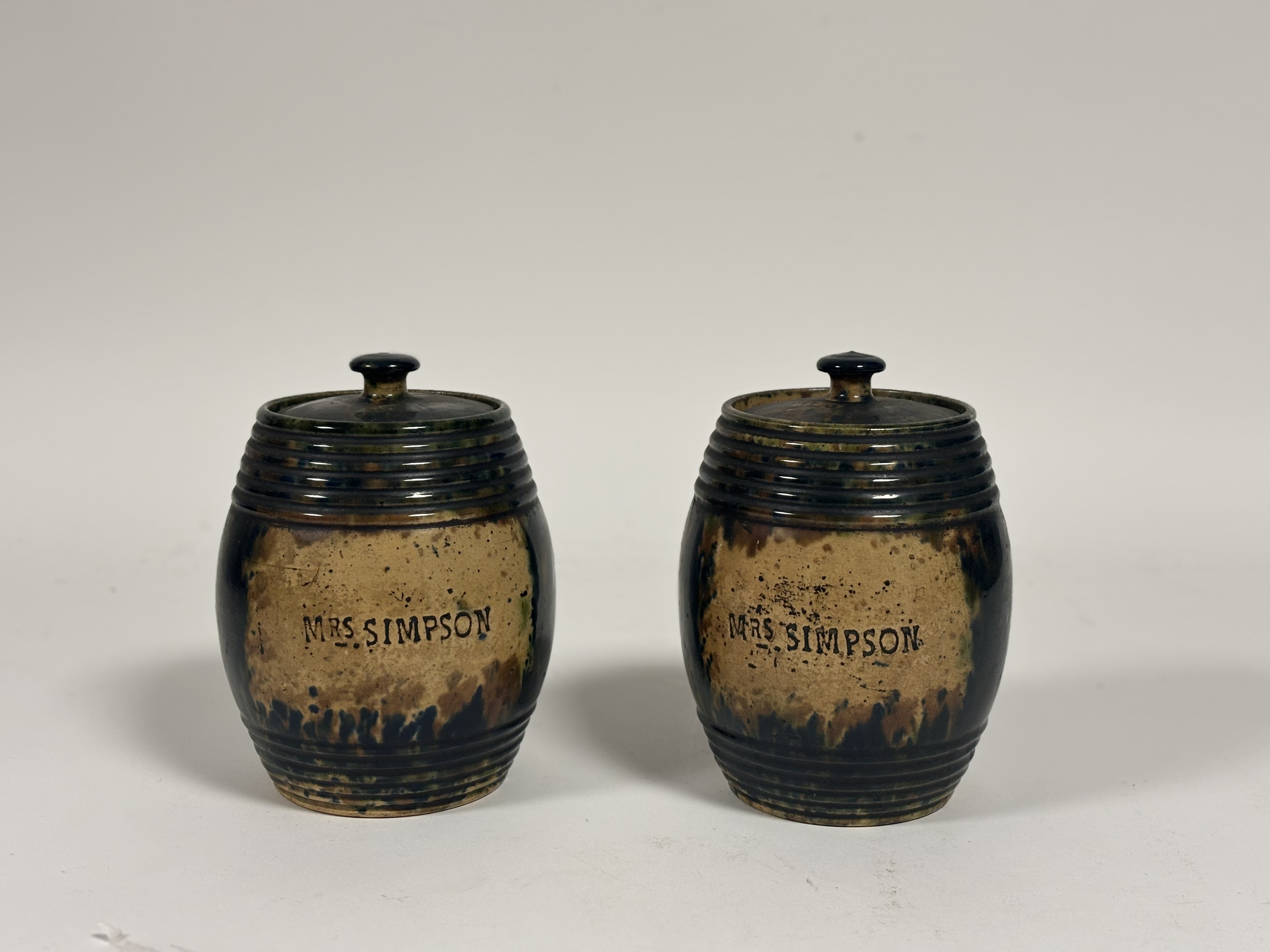 A pair of Scottish Pottery barrels with covers, both reading "Mrs.Simpson" to centre. ( chips to