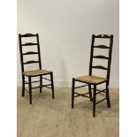 A pair of stained beech ladder back chairs, with string seats and turned front supports. H110cm