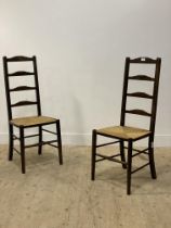 A pair of stained beech ladder back chairs, with string seats and turned front supports. H110cm