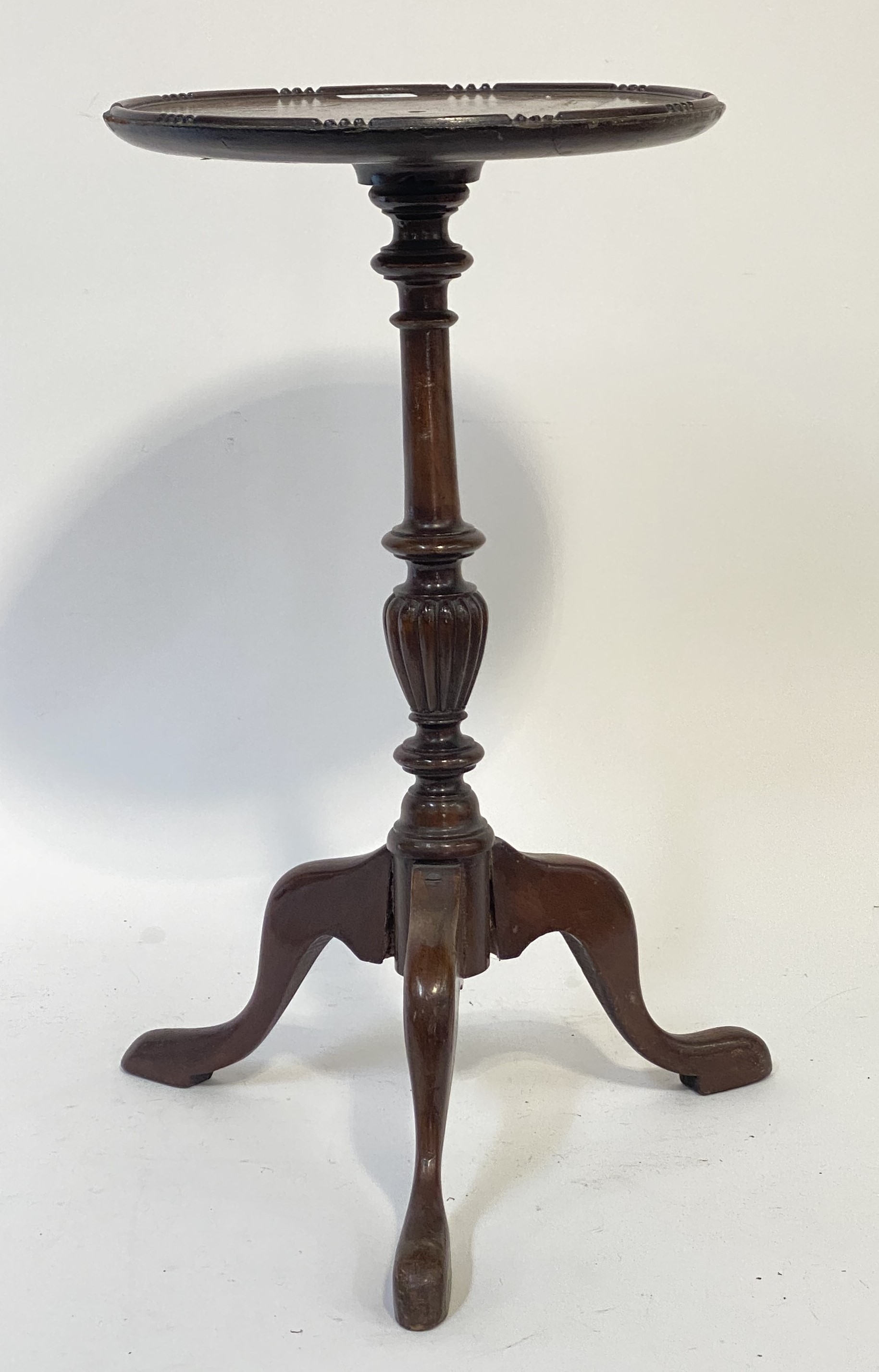 A Georgian style mahogany tripod wine table, the circular top raised on a turned column and triple