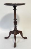 A Georgian style mahogany tripod wine table, the circular top raised on a turned column and triple