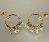 A pair of yellow metal wire woven circular hoop drop earings with cultured pearl set posts and