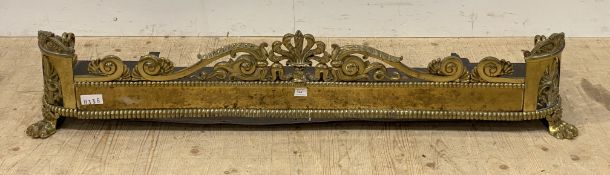 A well cast 19th century brass fire fender, decorated with open scrolls and anthemion motifs, raised