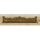 A well cast 19th century brass fire fender, decorated with open scrolls and anthemion motifs, raised