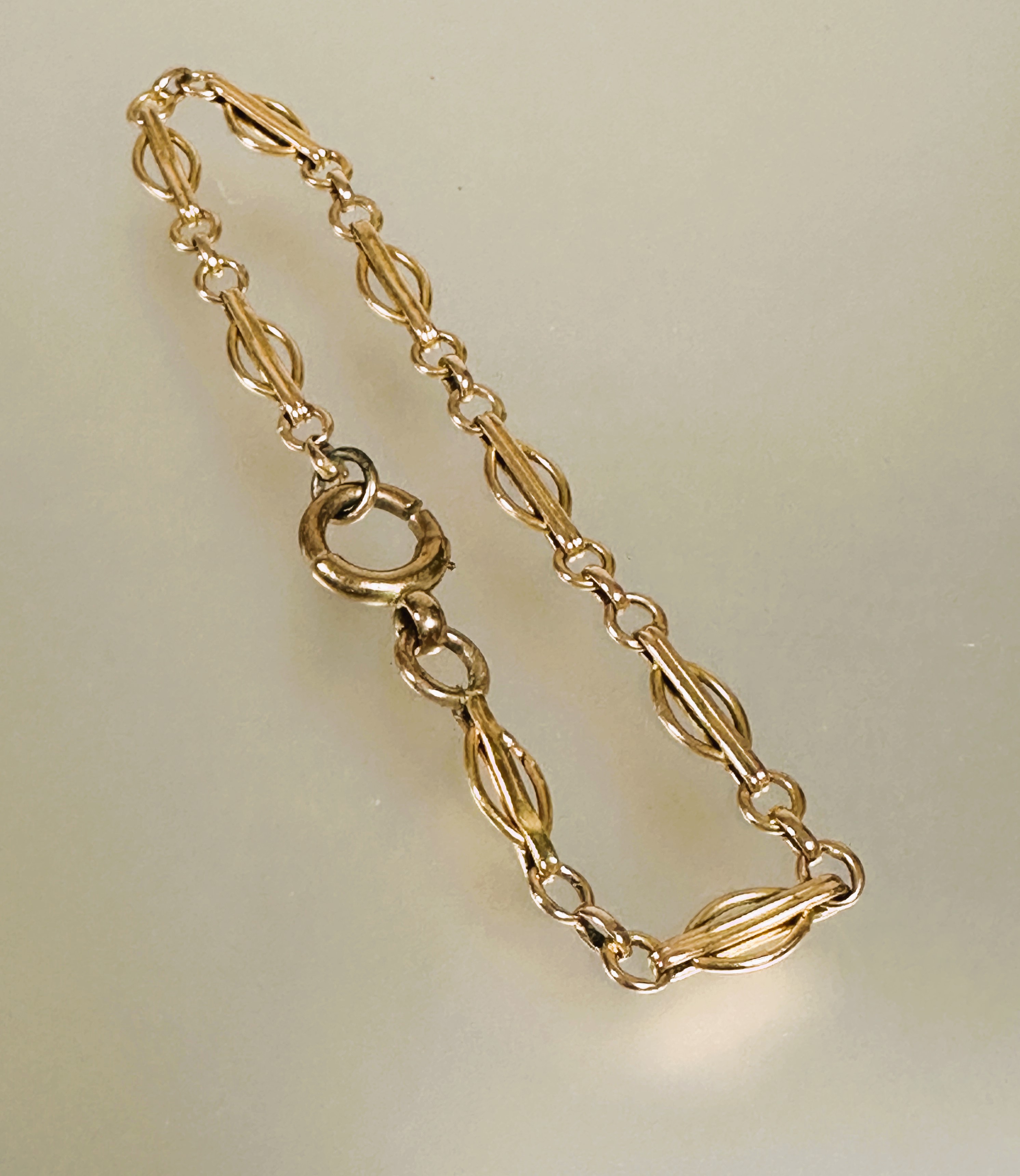 A 9ct gold oval bar and chain link bracelet with loop clasp fastening D x 9cm 4.56g